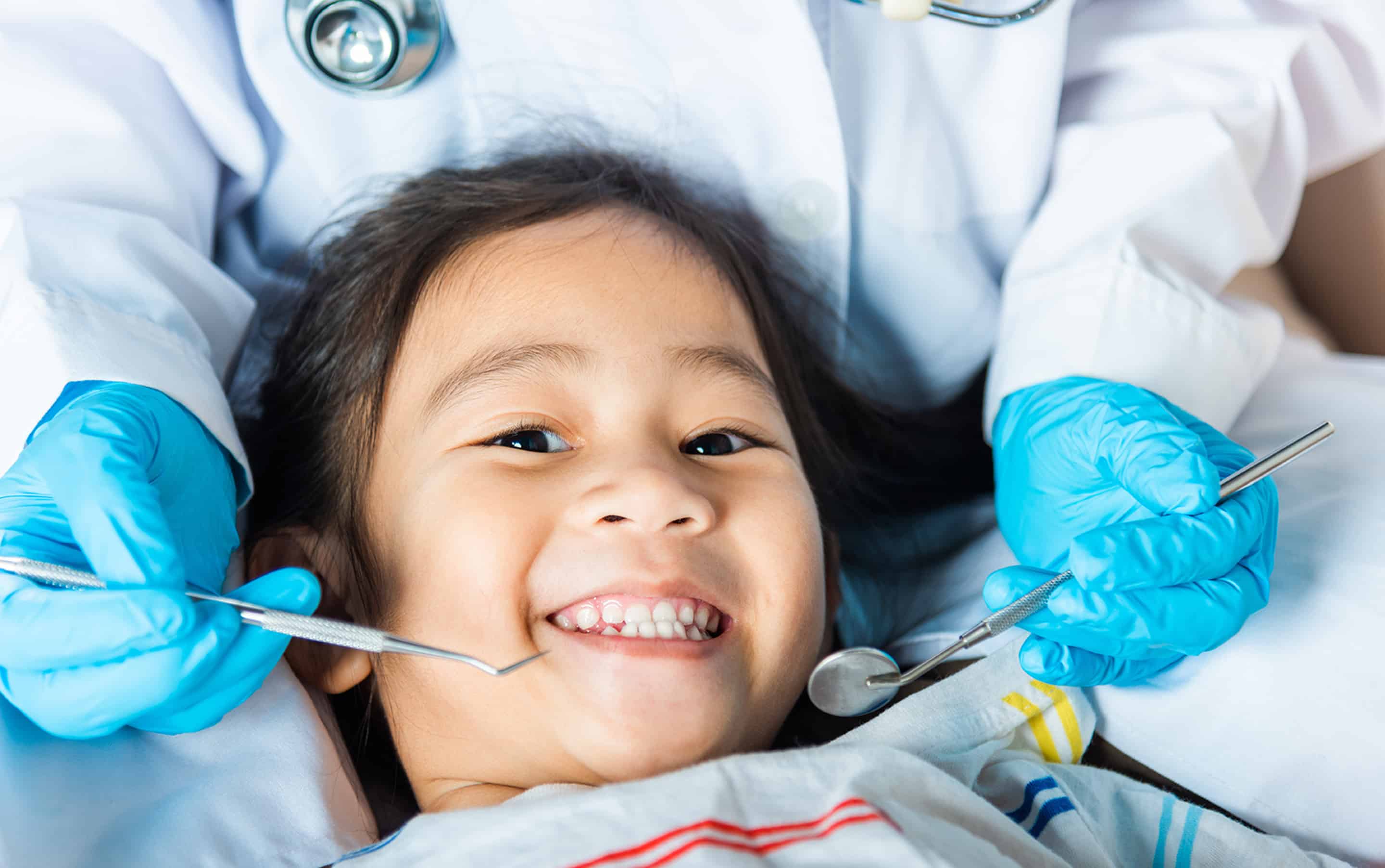 Young girl getting a comprehensive dental exam and cleaning in Lawrence, KS and Lenexa, KS