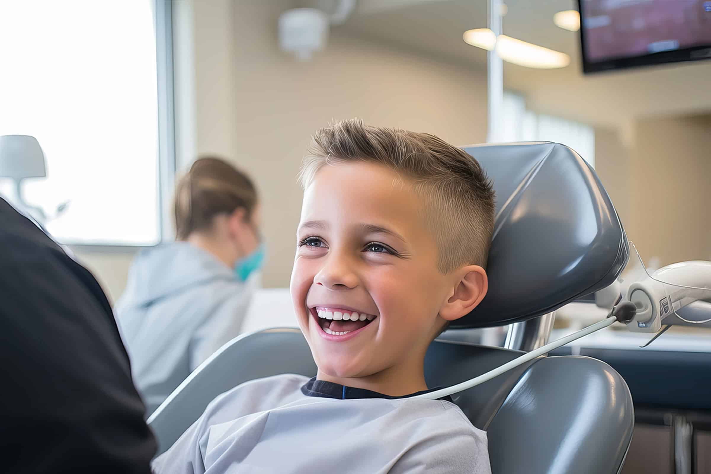 Young boy smiling at the dentist after getting a tooth-colored filling in Lenexa, KS