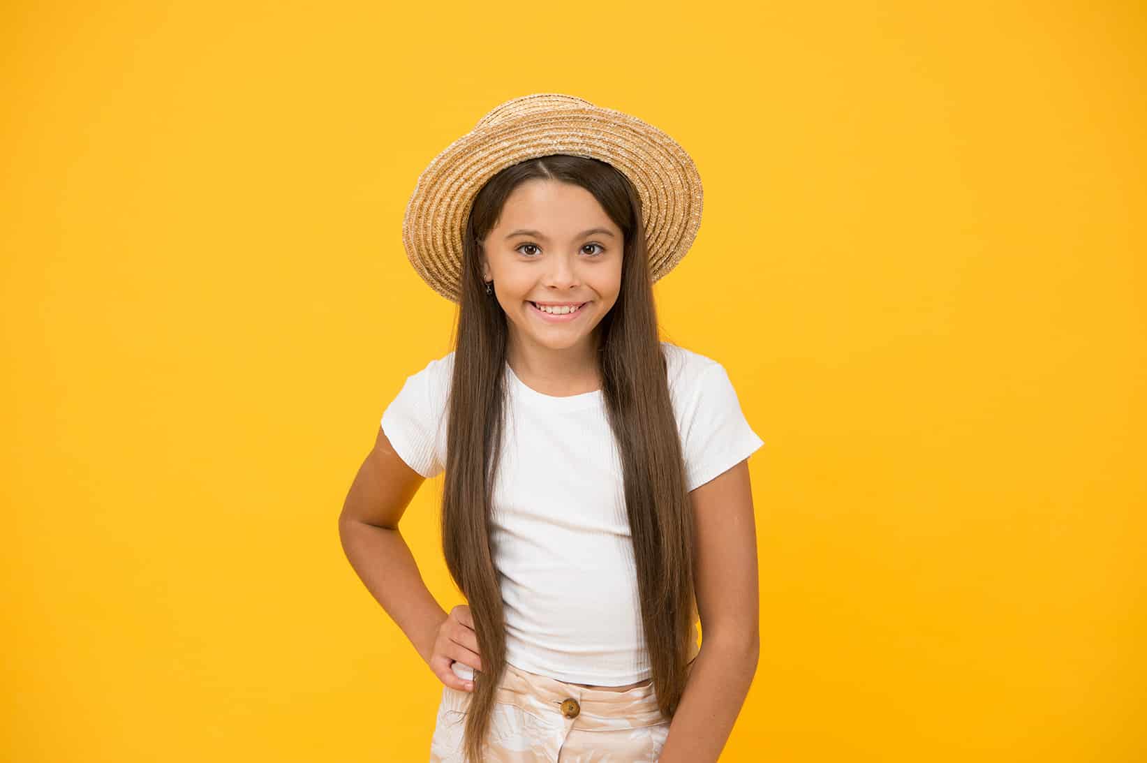 young girl smiling with hat - Honey Bee Pediatric Dental Co.