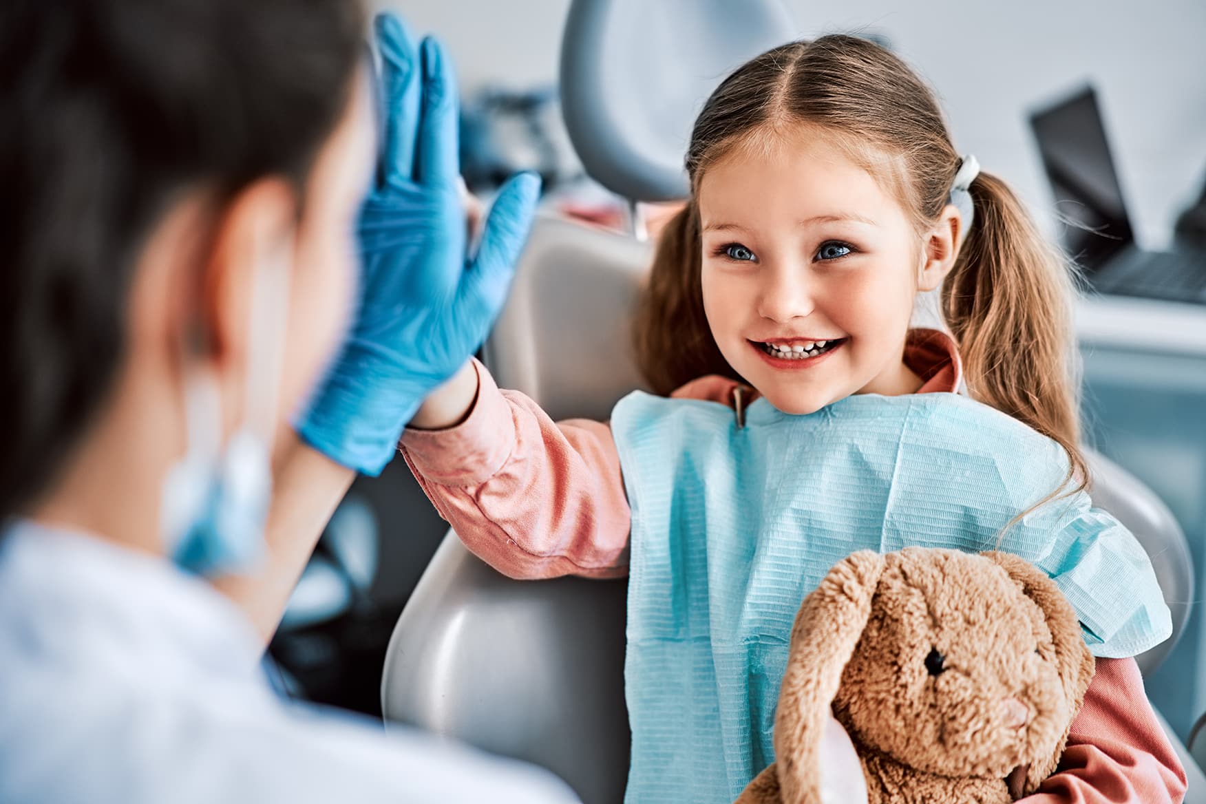 girl giving a high five to a dentist during dental appointment at honey bee pediatric co