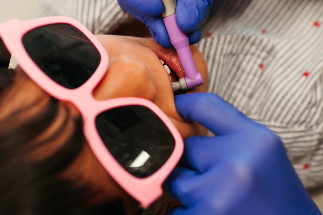 young girl smiling with hat - Honey Bee Pediatric Dental Co.